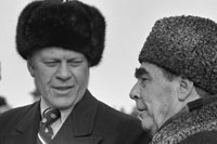President Ford dons a Russian wool cap upon his arrival in Soviet Union, shown here with Soviet General Secretary Leonid Brezhnev at Vozdvizhenka Airport, Vladivostok, USSR.  November 23, 1974
