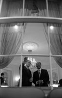President Ford and Egyptian President Anwar Sadat look out the window of the Yellow Oval Room during a pre-State Dinner reception.  October 27, 1975.  