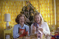 Having selected “handmade and folksy” as the theme for Christmas at the White House, First Lady Betty Ford makes homemade ornaments with daughter Susan for the tree in the third floor Solarium during a photo-op for Parade Magazine.  November 10, 1975.   