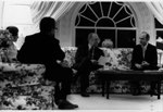 A4233-7A. President Ford discusses the evacuation of Saigon with national security advisers Henry Kissinger and Brent Scowcroft during an evening meeting in the White House residence. Mrs. Ford is also present. April 28, 1975.