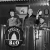 Photograph of President Truman and Prime Minister Churchill standing on the rear platform of a special Baltimore & Ohio train (evidently en route to Fulton, Missouri for Churchill's "Iron Curtain" Speech), with the President's Military Aide, General Harry Vaughan, seated nearby., 03/04/1946? 