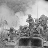 Vietnam....Marines riding atop an M-48 tank cover their ears as te 90mm gun fires during a road sweep southwest of Phu Bai., 04/03/1968 