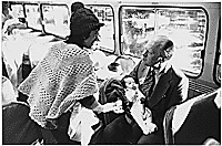 President Gerald R. Ford talks to a woman refugee while holding a Vietnamese baby
