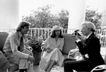 Andy Warhol takes a photograph of Jack Ford as Bianca Jagger looks on