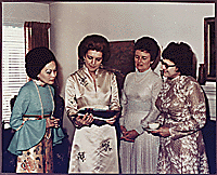 H0001-2. Betty Ford and three unidentified women looking at photographs. 1972.