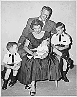 H0006-3. Mrs. Ford holds Steven Ford as Gerald R. Ford, Jr., Jack Ford, and Michael Ford look on. June 1956.