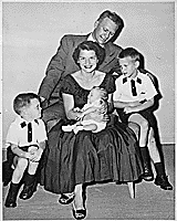 H0007-4. Mrs. Ford holds Steven Ford as Gerald R. Ford, Jr., Jack Ford, and Michael Ford look on. June 1956.