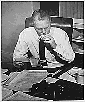 H0011-4. Representative Gerald R. Ford, Jr., reads constituent mail while eating a sandwich at his desk in his House office. 1953.