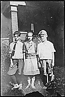 H0026-2. Gerald R. Ford, Jr. poses with his cousins Gardner and Adele James on the front lawn of an unidentified house. 1923. 