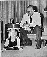H0042-4. Gerald R. Ford watches as his daughter Susan lies on the floor and reads from "Ten Apples Up On Top" in the living room of the Ford residence at 514 Crown View Drive, Alexandria, VA. 1964.