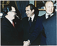 Senator Robert Griffin (MI) shakes hands with President Richard M. Nixon while Vice Presidential nominee Gerald R. Ford chats with a well-wisher at a reception in the Blue Room following Nixon's announcement of Ford as his choice to succeed Spiro T. Agnew.