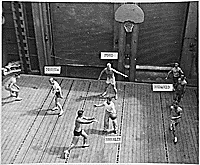 H0060-4. Gerald R. Ford, Jr. guards the net during a basketball game on the forward elevator of the USS MONTEREY. As physical education director it was Mr. Ford's idea to create a basketball court on the elevator. 1944.