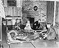 H0066-2. Mike, Jack, Steve, and Susan Ford play with an electric train in the Ford residence at 514 Crown View Drive, Alexandria, VA. December 1962.
