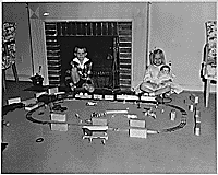 H0066-3. Steve, and Susan Ford play with an electric train in the Ford residence at 514 Crown View Drive, Alexandria, VA. December 1962.