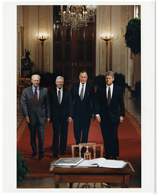 Former Presidents Gerald R. Ford, George H.W. Bush, and Jimmy Carter walking with President Bill Clinton to the East Room of the White House prior to the signing of the North American Free Trade Agreement (NAFTA).