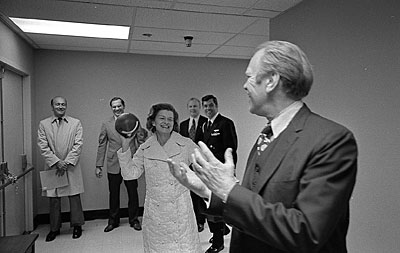 President and Mrs. Ford toss a football, a gift from Washington Redskins Coach George Allen, in the hallway near the Presidential Suite at the Bethesda Naval Hospital, Bethesda, MD, following the First Lady’s breast cancer surgery. 
