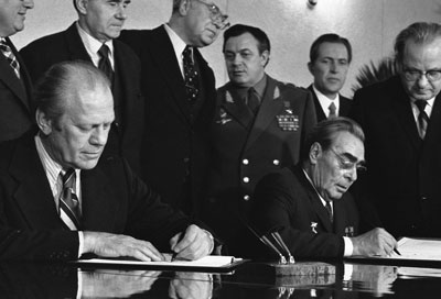 President Ford and Soviet General Secretary Leonid I. Brezhnev sign a Joint Communiqué following talks on the limitation of strategic offensive arms. The document was signed in the conference hall of the Okeansky Sanatorium, Vladivostok, USSR.
