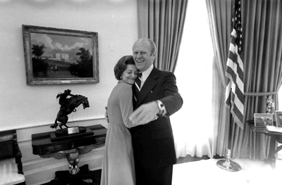 President and Mrs. Ford hug each other in the Oval Office.