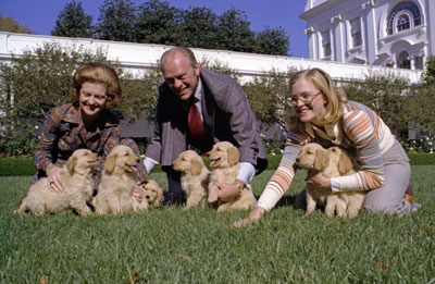 President and Mrs. Gerald R. Ford and daughter Susan play with Liberty’s golden retriever puppies on the South Lawn of the White House.   