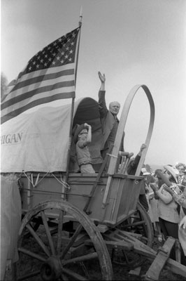 President Ford boards the Michigan wagon at the Bicentennial Wagon Train Pilgrimage encampment, where covered wagon trains converged after crossing the nation on historical trails.  