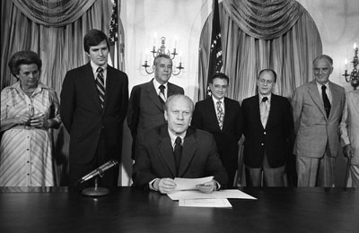 B1030-7A President Ford makes remarks prior to signing S.3735, authorizing the 1976 National Swine Flu Immunization Program.  August 12, 1976.  Also shown are [l-r]:  HEW Undersecretary Marjorie Lynch, HEW Secretary F. David Mathews, U.S. Rep. Tim Lee Carter (R-KY),  Assistant Secretary for Health (HEW) Dr. Theodore Cooper, HEW General Counsel William H. Taft, IV, and HEW Assistant General Counsel Bernard Feiner.
