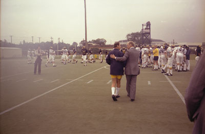 President Ford greets coach Bo Schembechler while heading for the practice field.