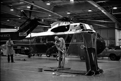 President Ford keeps in golf shape during a practice session in the Marine One Hangar at Andrews Air Force Base.  
