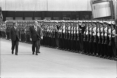 President Ford and Chancellor Helmut Schmidt review the honor guard at the Bonn/Cologne Airport during a farewell ceremony prior to Ford's departure from West Germany for Poland.
