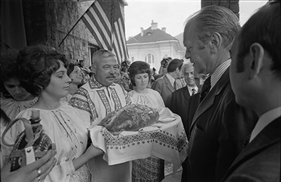 President Ford accepting bread and wine from a group of Romanians at Sinaia Train Station in Sinaia, Romania.