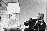 A4232-23A. President Gerald R. Ford takes a final phone call from Secretary of State Henry A. Kissinger, bringing him up to date on the situation in Vietnam, following a nighttime meeting in the West Sitting Room with the Secretary and Deputy National Security Adviser Brent Scowcroft, April 28, 1975.