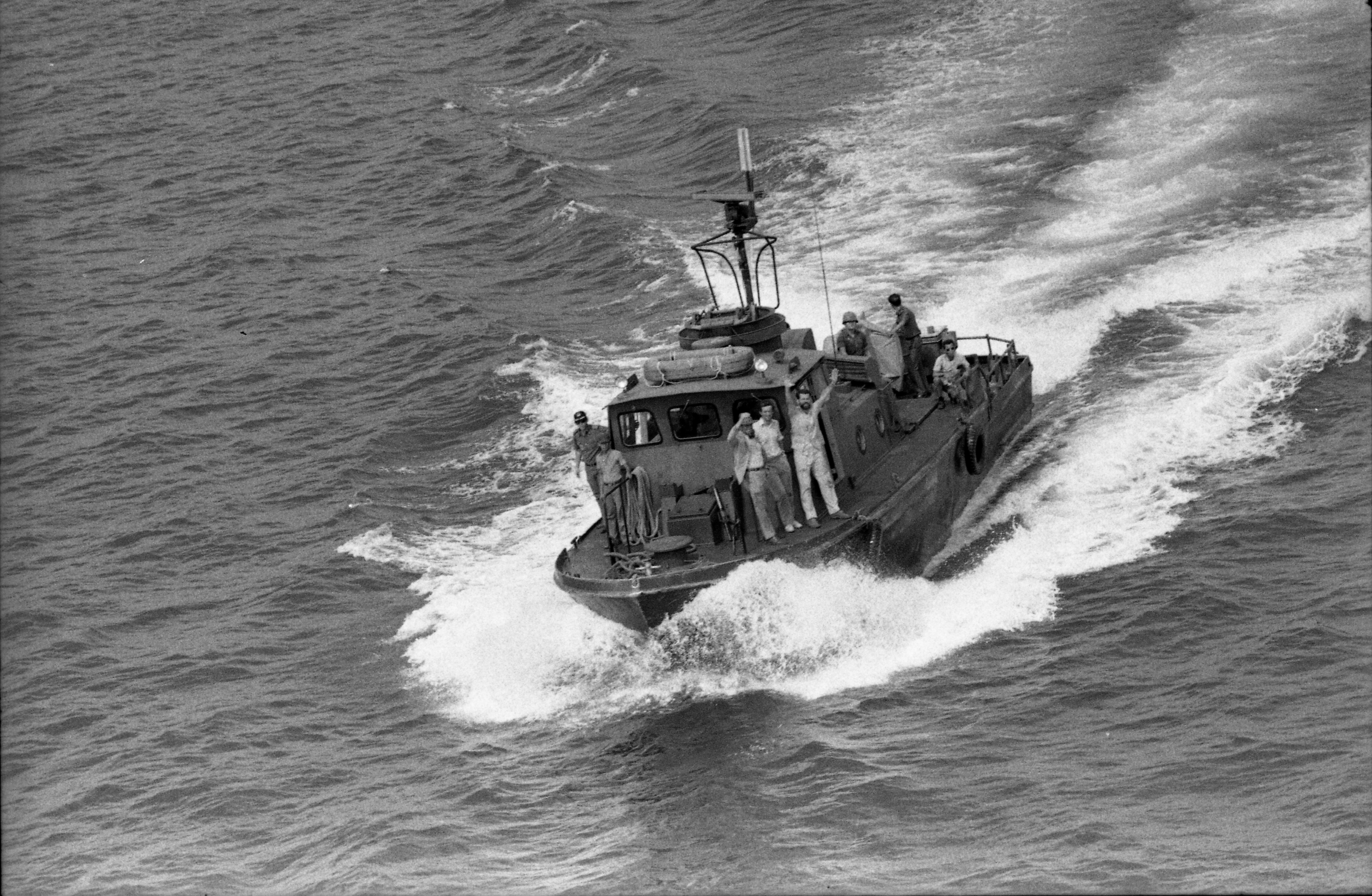 :U.S. Consul Al Francis waves from a tugboat in Cam Ranh Bay, South Vietnam, after escaping from Da Nang in front of the advancing Communists. March 30, 1975.
