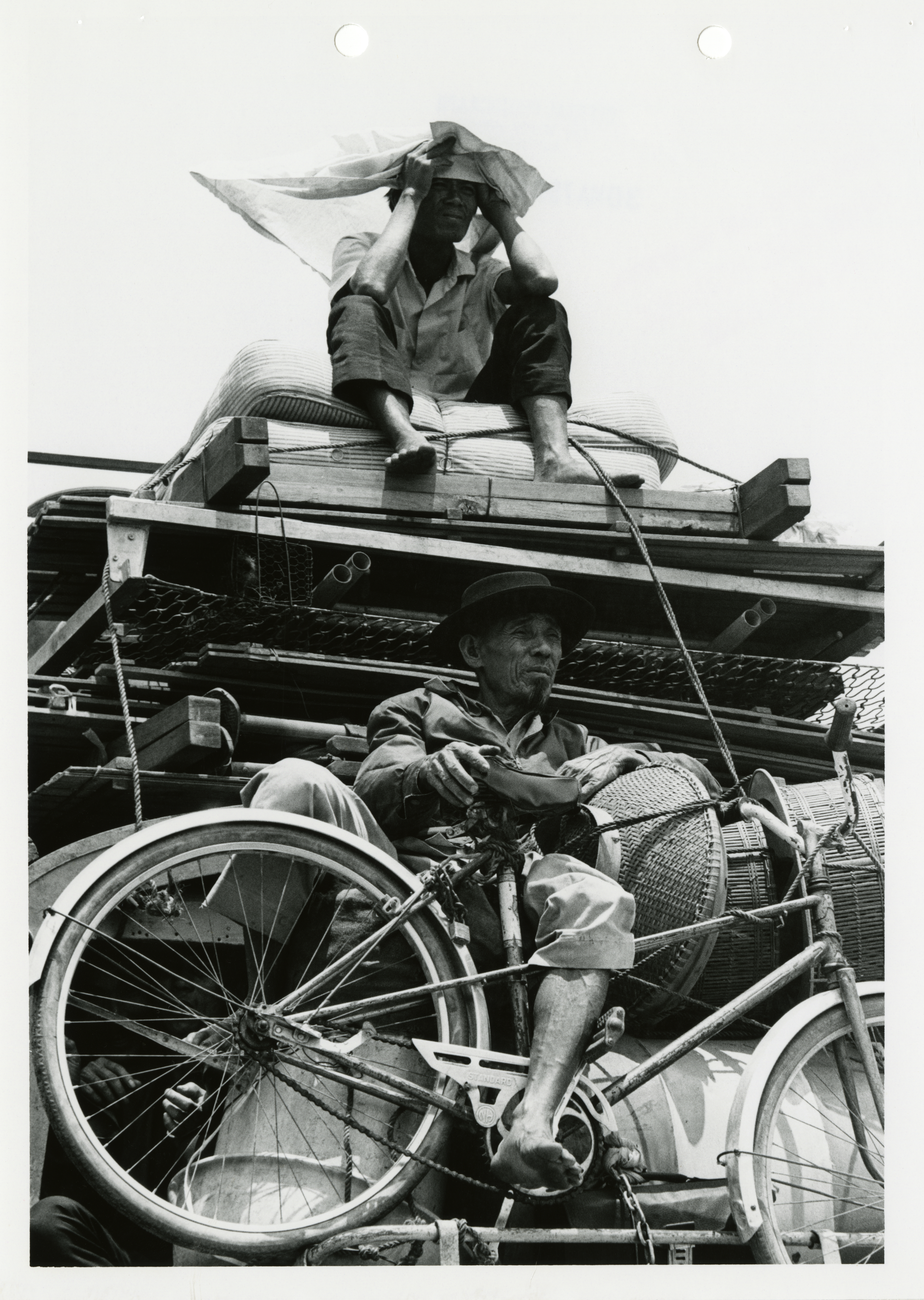 Refugees ride on the back of a truck between Cam Rahn Bay and Nha Trang, South Vietnam. March 30, 1975.