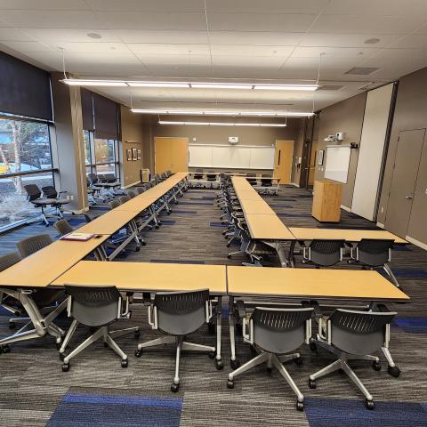 Two large U shaped tables with chairs is shown 