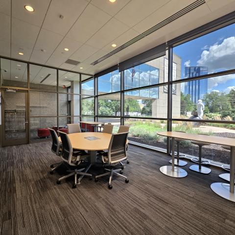 A small conference room with tables and chairs is shown