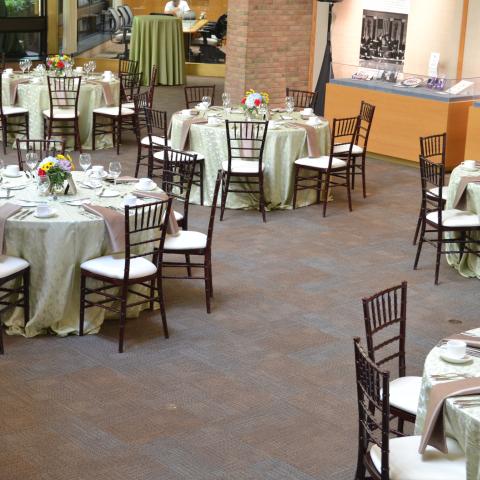 Round tables with tablecloths are set up across the room