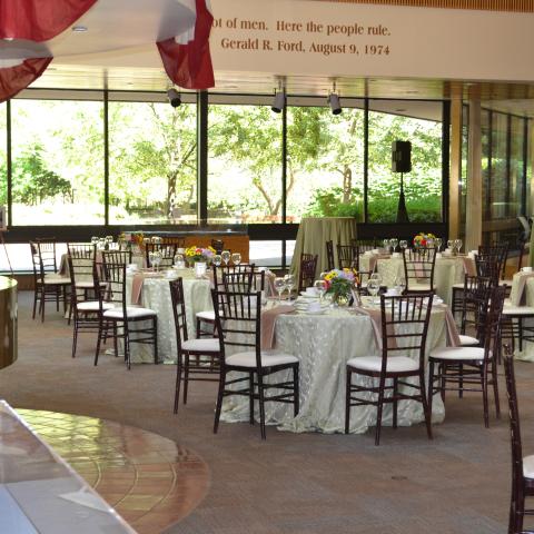 Round tables with tablecloths are set up across the room