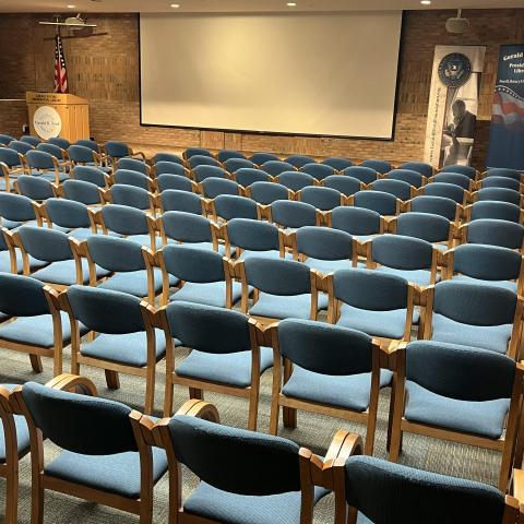 Chairs are aligned in rows facing a stage