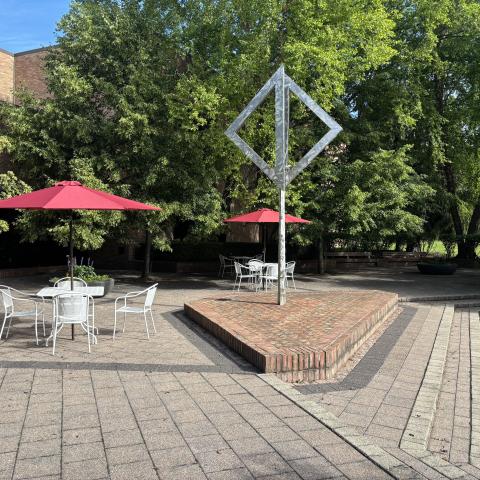 The back patio at the Library, paved with bricks, features art work and furniture.