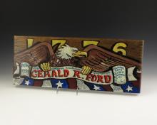 A wooden plank shows an eagle carrying a banner reading "Gerald R. Ford" in front of the numbers 1776