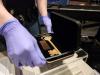 Intern with gloves on is adjusting a key artifact