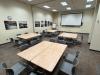 Tables in an empty classroom are set up in a pod formation with chairs
