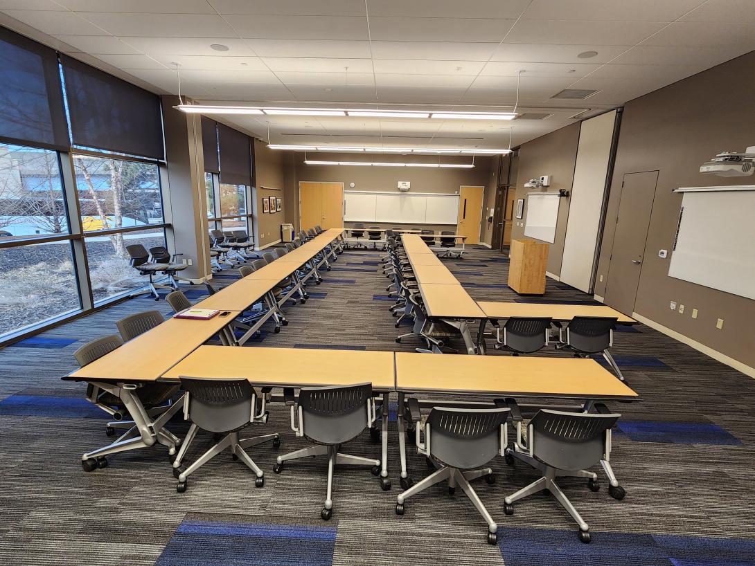 Two large U shaped tables with chairs is shown 