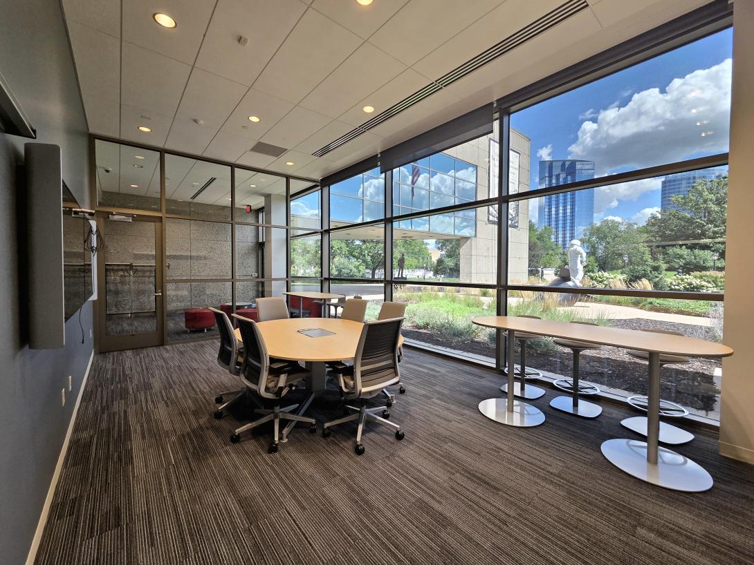 A small conference room with tables and chairs is shown