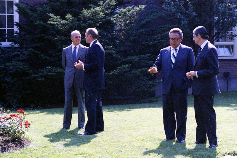 Gerald R. Ford talks to Constantine Caramanlis while Kissinger and Bitsio talk during the Luncheon Meeting with Prime Minister, Foreign Minister and Chief of Cabinet of Greece.