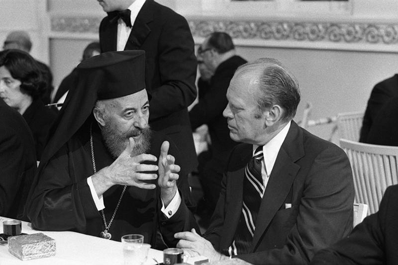 Gerald R. Ford and Archbishop Makarios are seated, talking.