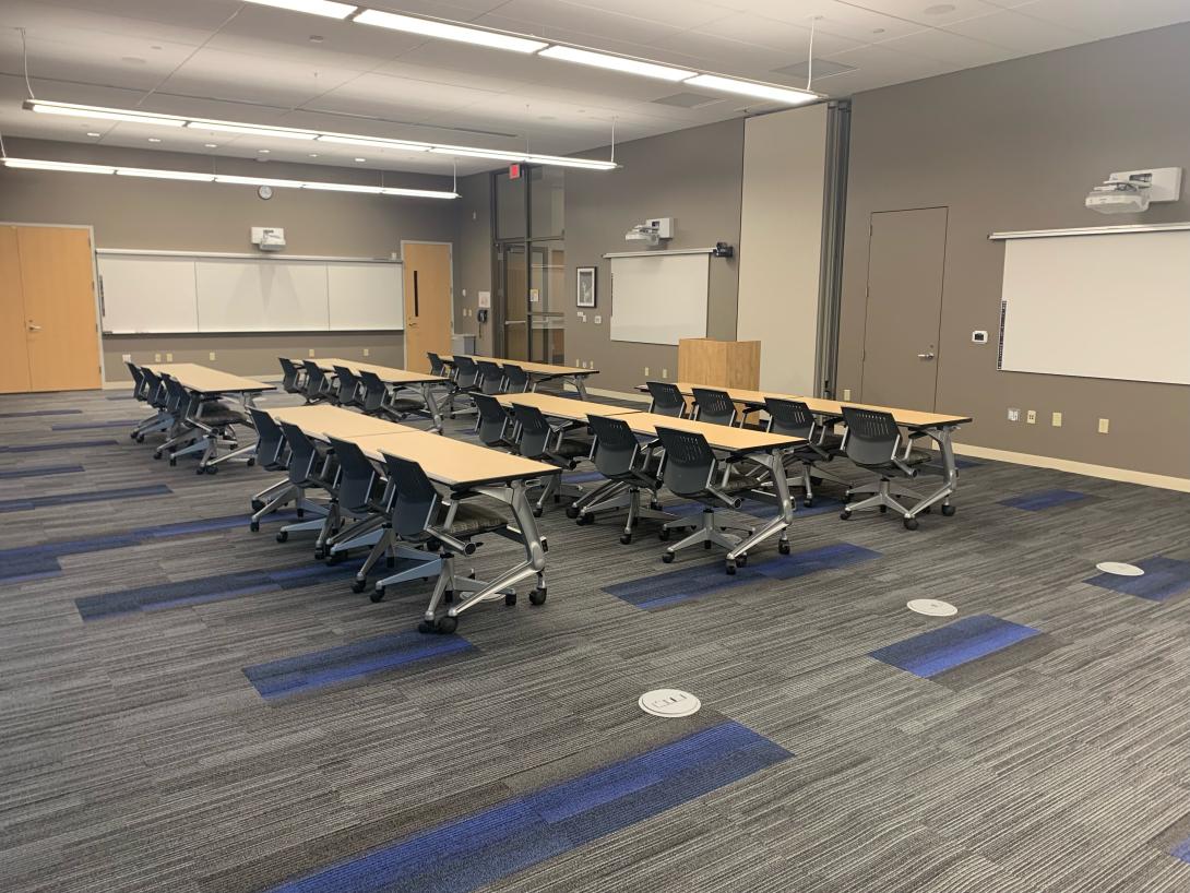 A large conference room with tables and chairs is shown