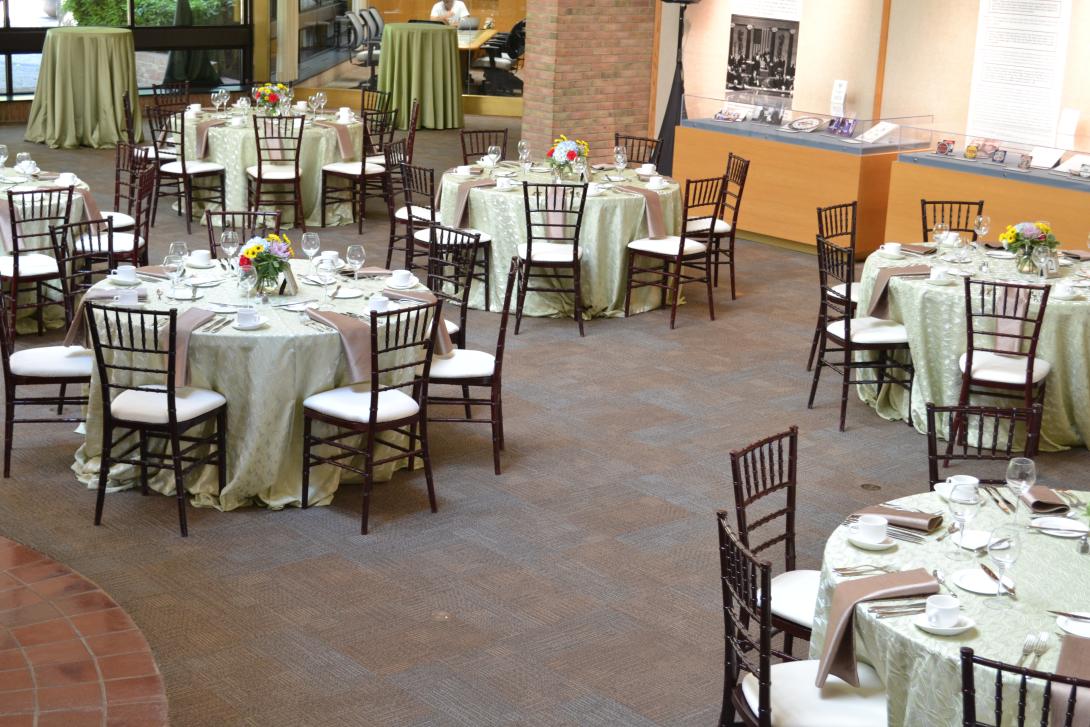Round tables with tablecloths are set up across the room