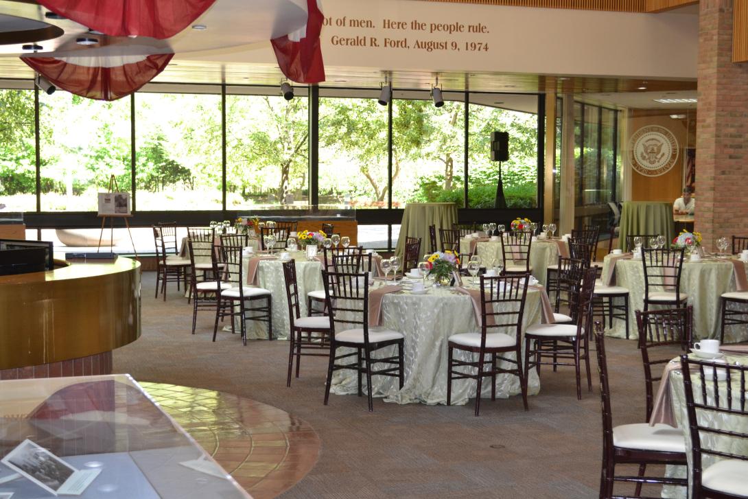 Round tables with tablecloths are set up across the room