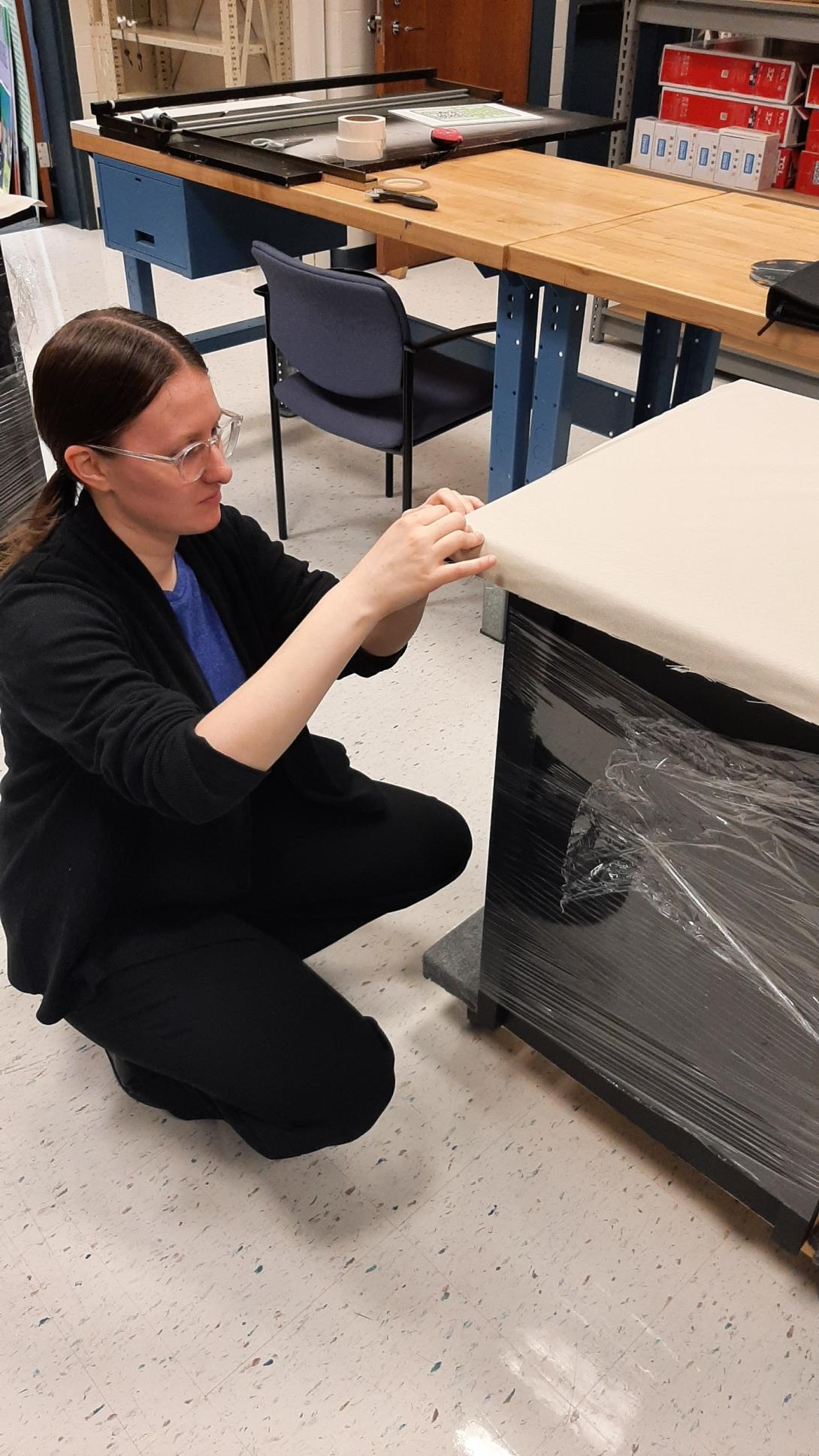 Intern is adjusting the protective wrap on a case