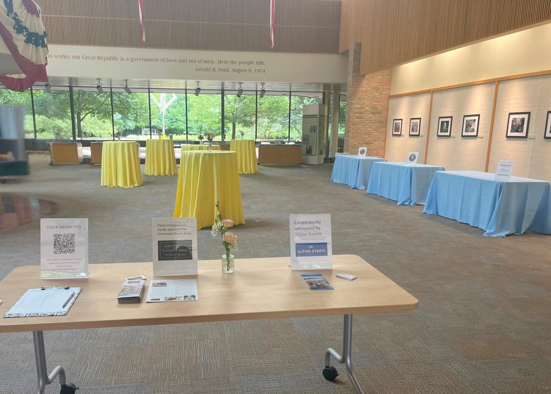 High top tables with yellow tablecloths and rectangular tables with blue tablecloths fill the lobby